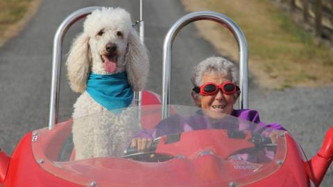 Norma Bauerschmidt and her dog in a car