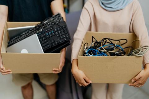 girl and boy holding boxes of electrical items