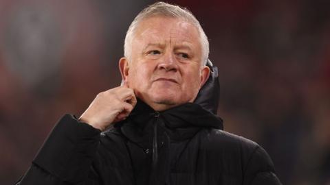 Sheffield United boss Chris Wilder grips the collar of his coat