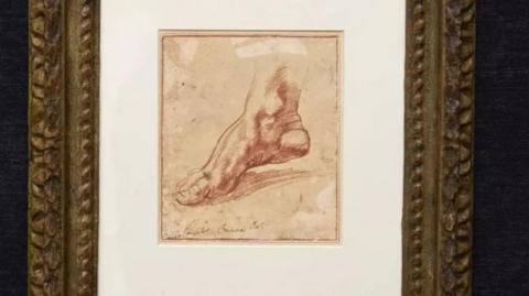 A small sketch of a foot made in red chalk in a gold frame