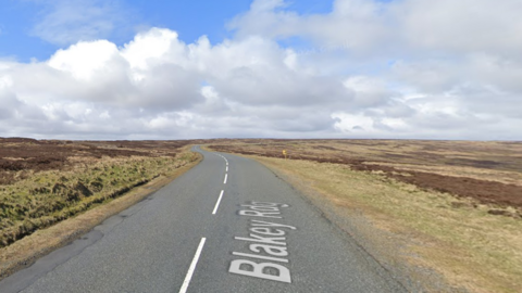 A road with moorland on either side of the road