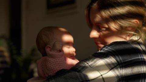 A mother looks lovingly at her newborn baby