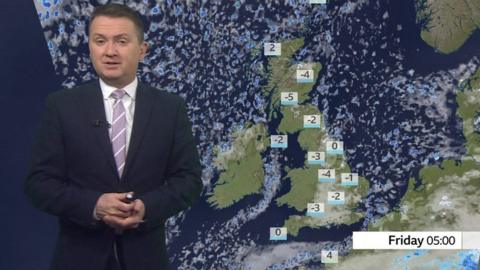 Matt Taylor standing in front of a weather map of the UK