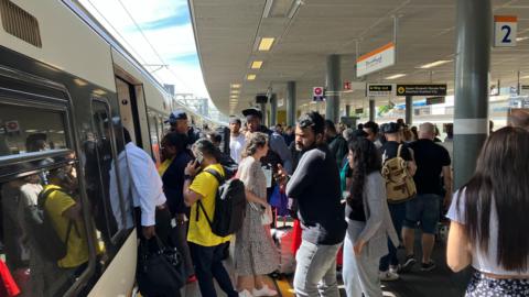 Commuters at a TfL station