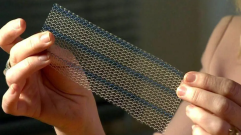 A woman holds a mesh implant in her hands