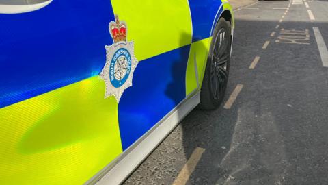 The side of a police car with the North Yorkshire Police logo on the door.