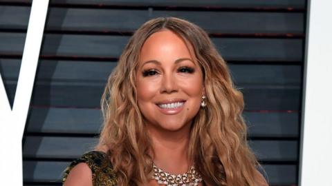 Mariah Carey smiling at the camera. 