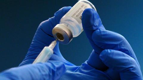 A hand holding a medical bottle.