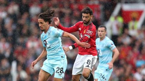 Manchester United skipper Bruno Fernandes challenges Burnley midfielder Hannibal Mejbri at Old Trafford