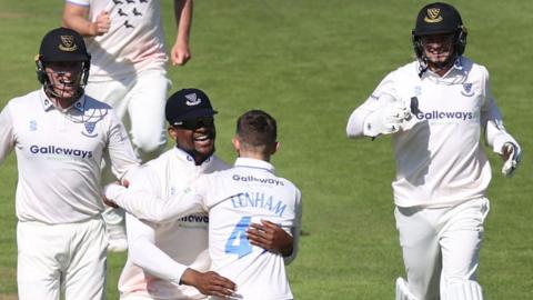 Archie Lenham is congratulated for taking a wicket