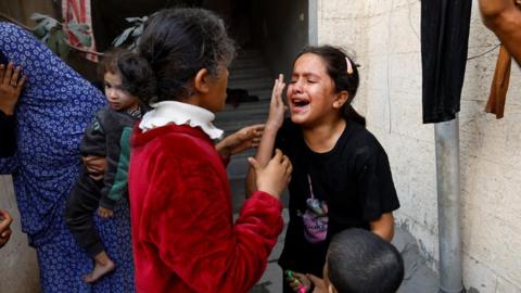 Palestinian children react after an Israeli strike on a house in Khan Younis