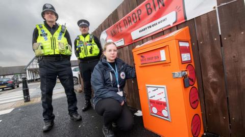 North Yorkshire Council community safety officer, Evie Griffiths, with North Yorkshire Police officers, PCs Kelvin Troughton and Brendon Frith, at the knife drop bin in Harrogate