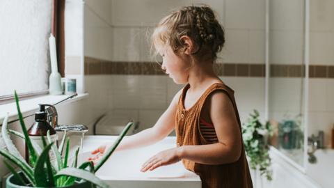 Child washing hands in a sink