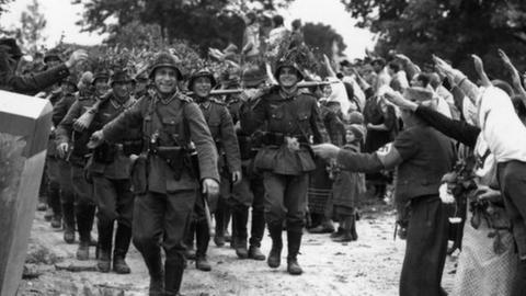 Wehrmacht soldiers entering Czechoslovakia in 1938 as locals salute