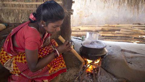 Woman cooking with firewood in India