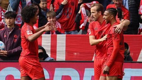 Serge Gnabry and Harry Kane celebrate with Michael Olise who scores Bayern Munich's second Bundesliga goal against Mainz
