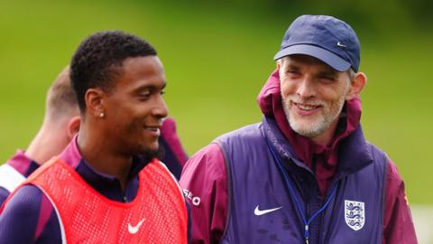 Defender Ezri Konsa and head coach Thomas Tuchel smile during England training