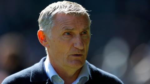 Tony Mowbray, wearing a blue jacket and light blue collared shirt, while on the touchline as West Brom boss in April 2025