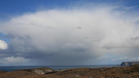 Huge shower cloud looming over sea