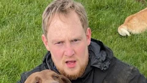 Rhydian Jamieson holding brown dog