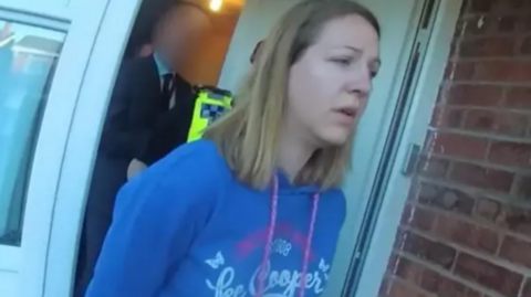 Lucy Letby, pictured in a blue top, during her arrest at her home in 2018.