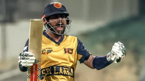 Kusal Mendis celebrates Sri Lanka's qualification by holding his bat and cheering