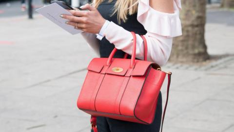 Close up image of a woman holding a red Mulberry Bayswater bag