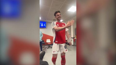 Declan Rice wearing an Arsenal kit in a changing room