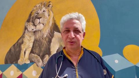 Dr Domenico Cipolla standing in front of a mural