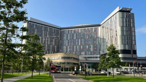A modern hospital building with multi-coloured panels on its sides
