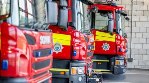 Three fire engines from West Susses Fire and Rescue Service parked at base.