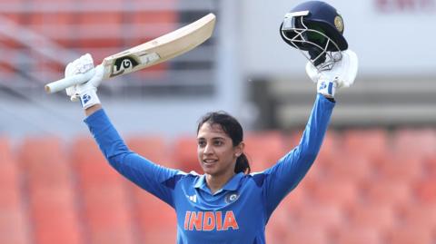 India's Smriti Mandhana raises her bat after reaching an ODI century against Australia at New Chandigarh