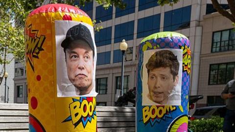 Punching bags with the faces of Musk and Altman seen outside of court