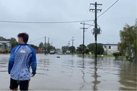 A teenage boy wades through floodwaters in north Queensland