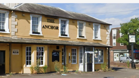 Anchor pub in Knaphill near Woking, sign on building, tree, shops nearby