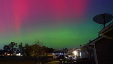 The northern lights can be seen as a greenish haze in the evening sky over Toronto.  
