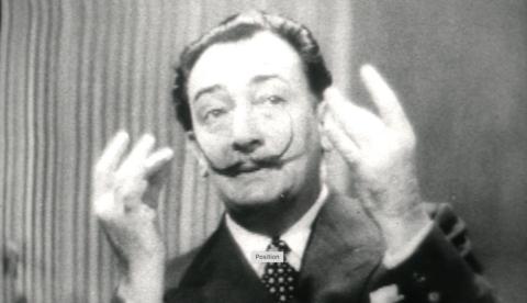 Salvador Dali gesturing to his moustache.