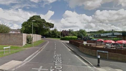 Junction into Cordale Road, Basingstoke - a pub garden can be seen on the right and houses behind a wall on the left.