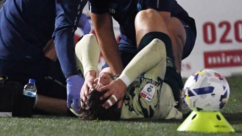Cardiff winger Ollie Tanner reacts in pain after being injured against Wimbledon