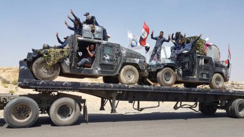 Iraqi federal police armoured vehicles are transported to the frontline outside Tal Afar (15 August 2017)