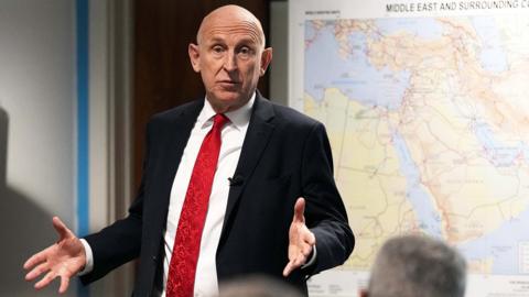 John Healey at presentation in front of map of middle east