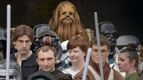 Fans wearing Star Wars costumes at a convention