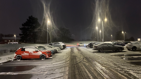 Snow on a car par with several cars