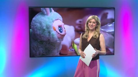 Jenny in the studio with a Labubu in the screen