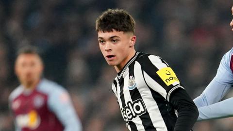 Lewis Miley plays football. He has short dark hair and is wearing the famous black and white stripes of Newcastle United.