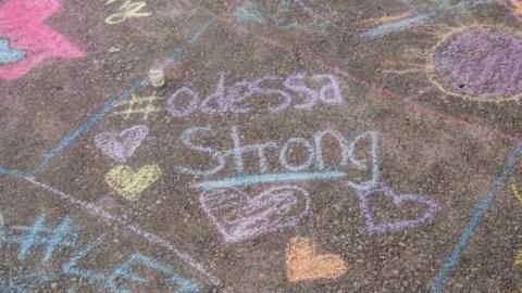 A chalk message reading "#Odessa Strong" written on the ground at a vigil for the victims of a mass shooting in Odessa, Texas