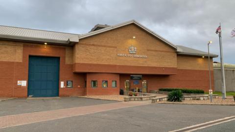 A large brick prison building with the sign "HMP & YOI Doncaster".