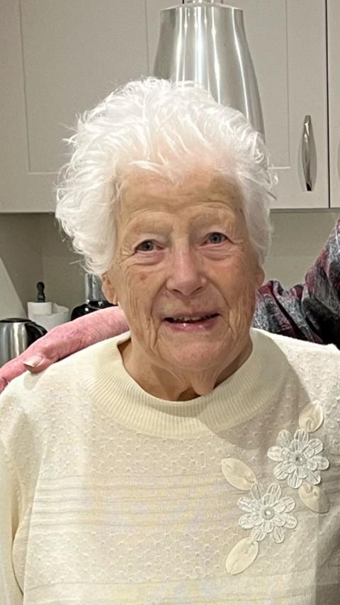 An elderly woman in a yellow top.