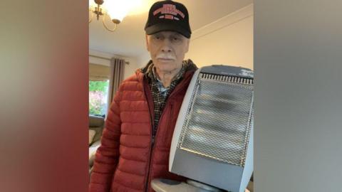 Keith Powell holding a heater