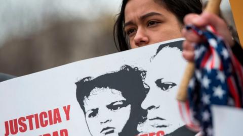 A young girl looks on as other immigrants and activists protest near the White House